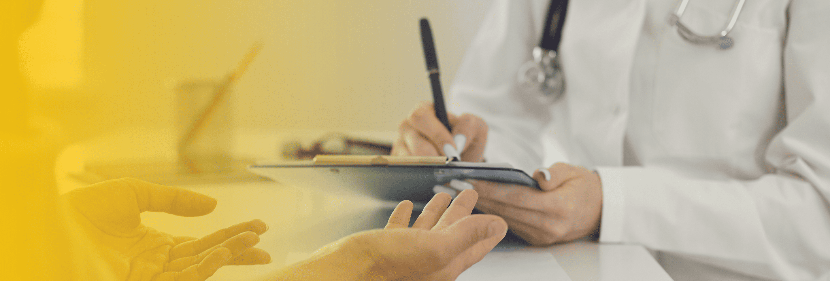 Doctor writing on clipboard during patient consult